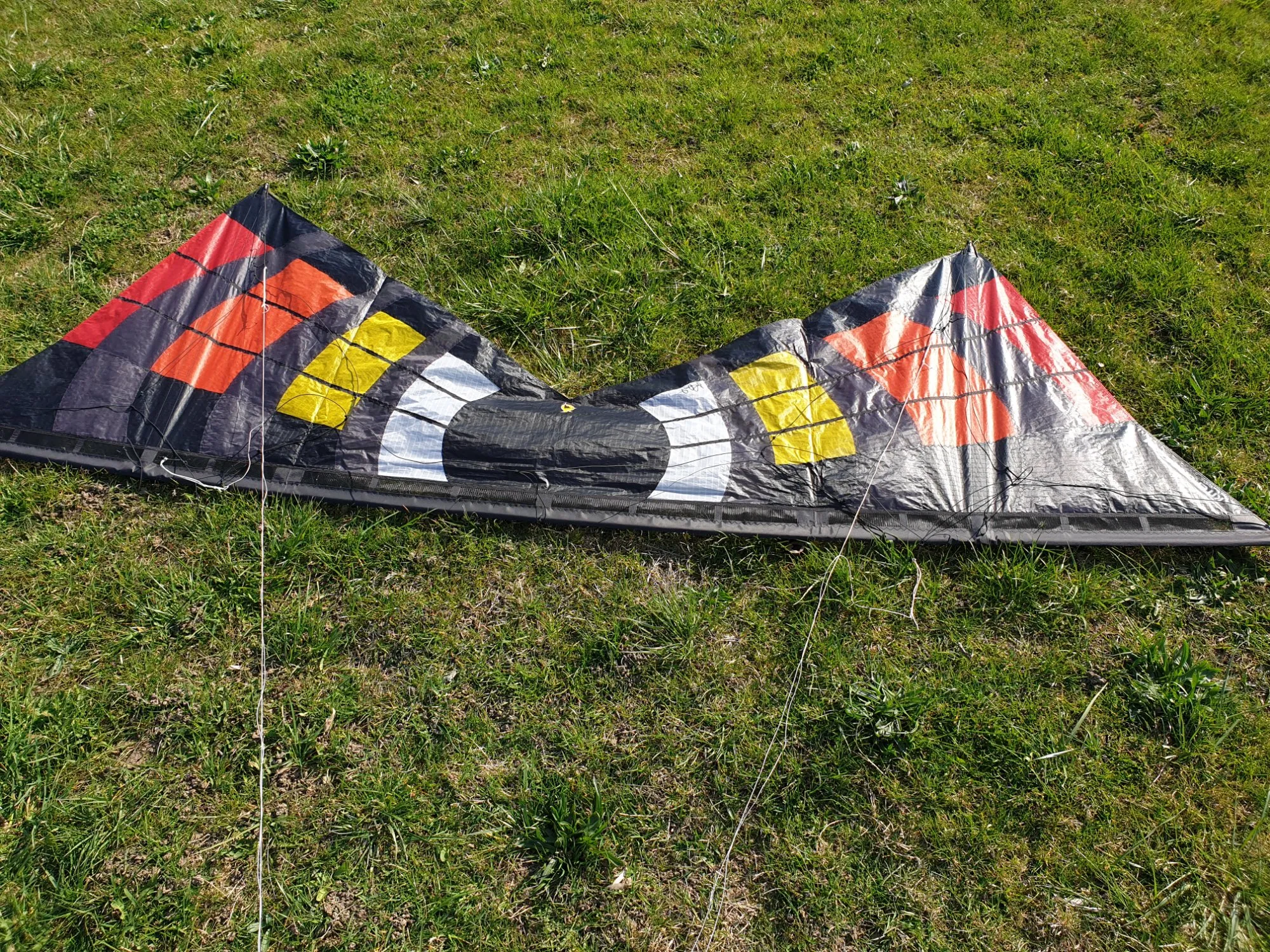 Kite lying on its back, wingtips away, before lifting