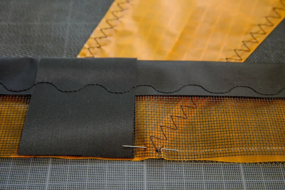 Attaching the leading edge to the sail, then sewing