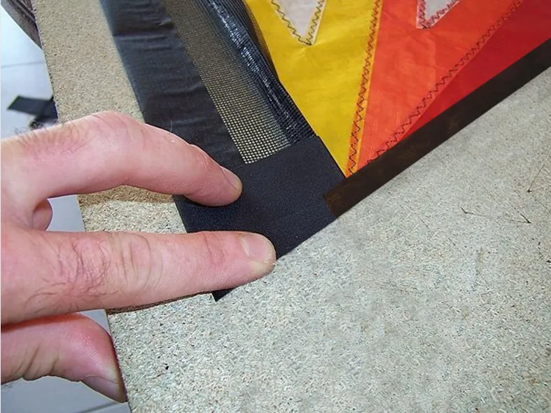 Fold the black spinnaker from the side hem inwards (so as not to cut it!) and then cut the Dacron/Gas/Icarex assembly along the red dotted line.
